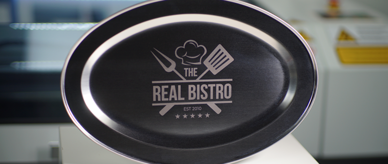 Eine Gravur des Logos eines Restaurants auf einer Edelstahlplatte.